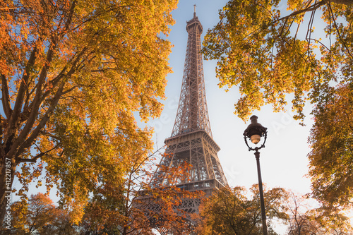 The iconic Eiffel Tower framed by vibrant autumnal foliage in Paris, France. © Stephen