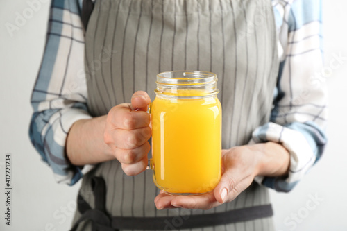 Woman holding mason jar of immunity boosting drink in hands, closeup