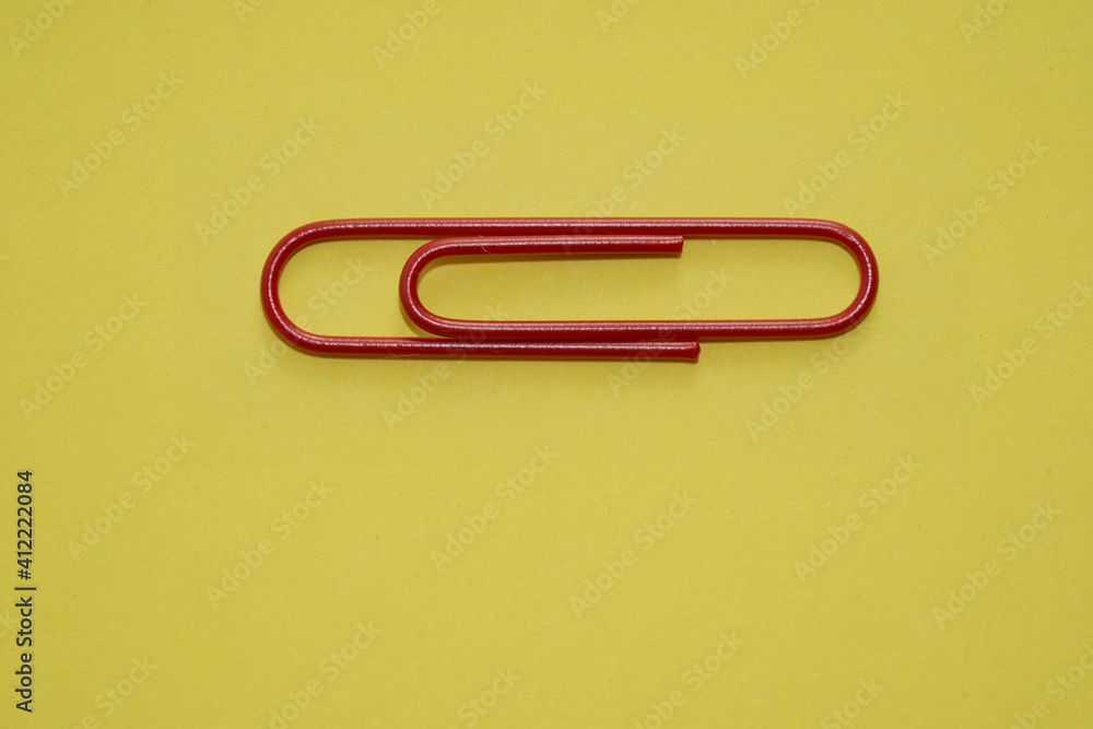 red paper clips on yellow background red paper clips on yellow background
