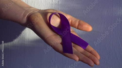 Hands holding purple ribbons, toning copy background, Alzheimer's disease, pancreatic cancer, epilepsy awareness, domestic violence awareness, fibromyalgia awareness, world cancer day photo