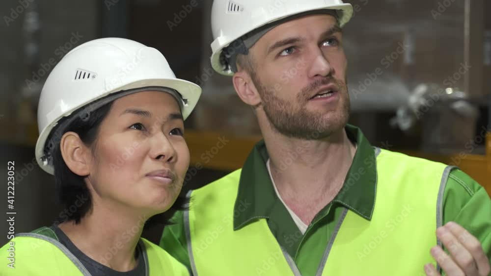 male and woman colleagues in uniform discuss working process. warehouse coworkers checking talking about merchandise goods. concept logistics, shelves of boxes, export. male and woman colleagues in uniform discuss working process. warehouse coworkers checking talking about merchandise goods. concept logistics, shelves of boxes, export.