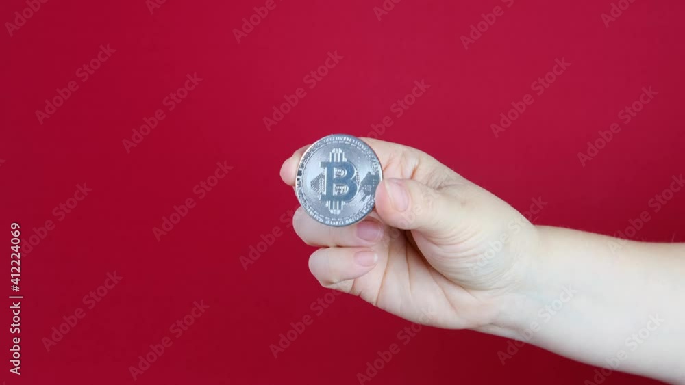 female hand hold coin silver bitcoin on red background, sale charts, up and down concept, banking, saving money female hand hold coin silver bitcoin on red background, sale charts, up and down concept, banking, saving money