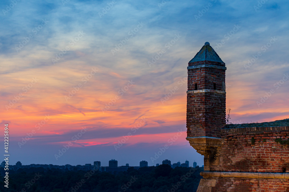 Old castle tower in the colorful sunset sky