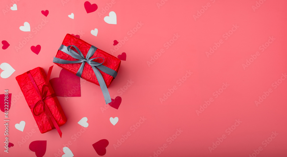 Two gifts for valentine's day. Boxes in red packaging on a pink background with hearts. Banner. Place for your text. Two gifts for valentine's day. Boxes in red packaging on a pink background with hearts. Banner. Place for your text.