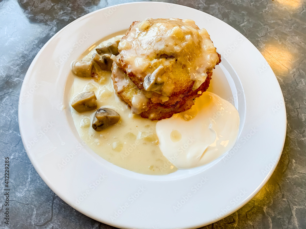 Potato pancakes, sauce with mushrooms in white plate. Studio Photo
