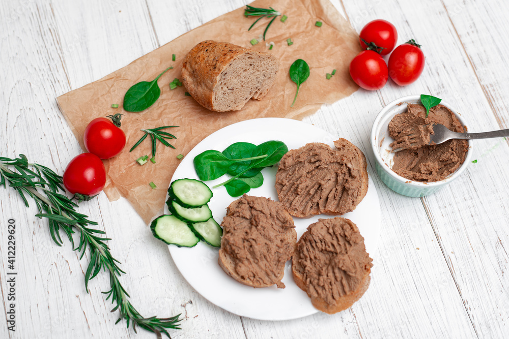 Sandwiches, canapes with chicken pate, tomatoes and cucumbers. On a white wooden background. Sandwiches, canapes with chicken pate, tomatoes and cucumbers. On a white wooden background.