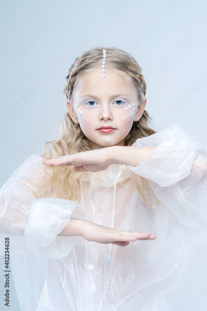 Portrait of a little beautiful girl. A fabulous image of a robot or an alien. Beautiful white makeup. Portrait of a little beautiful girl. A fabulous image of a robot or an alien. Beautiful white makeup.