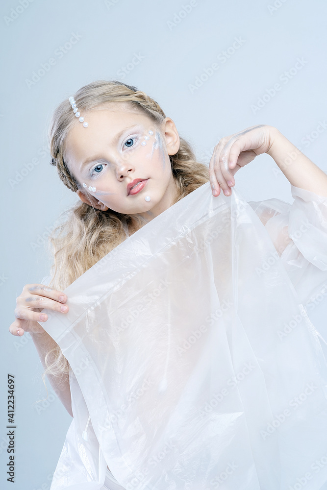 Portrait of a little beautiful girl. A fabulous image of a robot or an alien. Beautiful white makeup. Portrait of a little beautiful girl. A fabulous image of a robot or an alien. Beautiful white makeup.