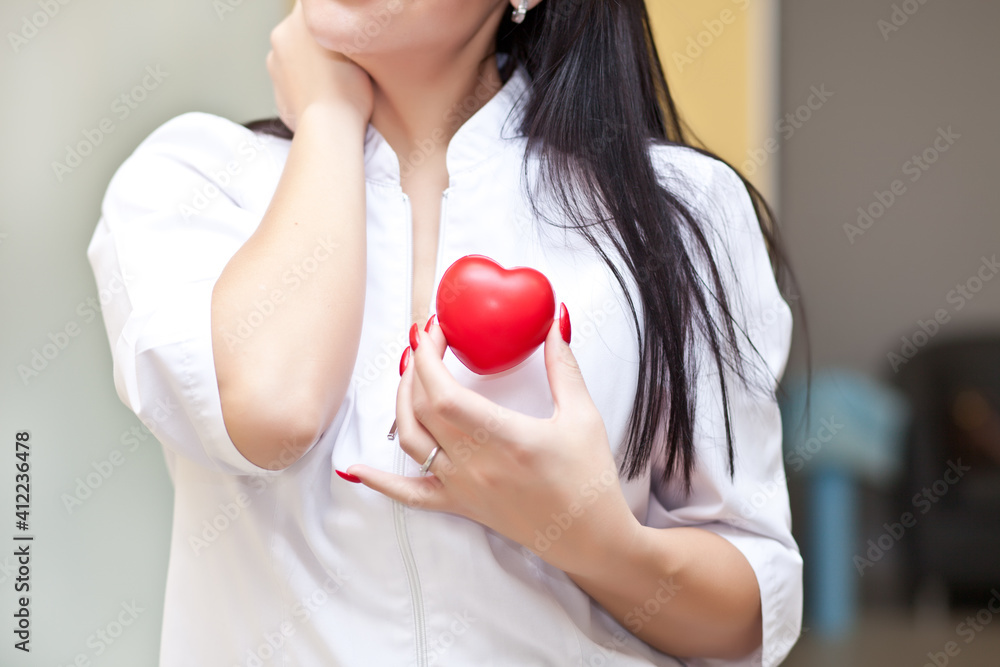 Woman in a medical uniform holding a heart in a hands. Woman in a medical uniform holding a heart in a hands.