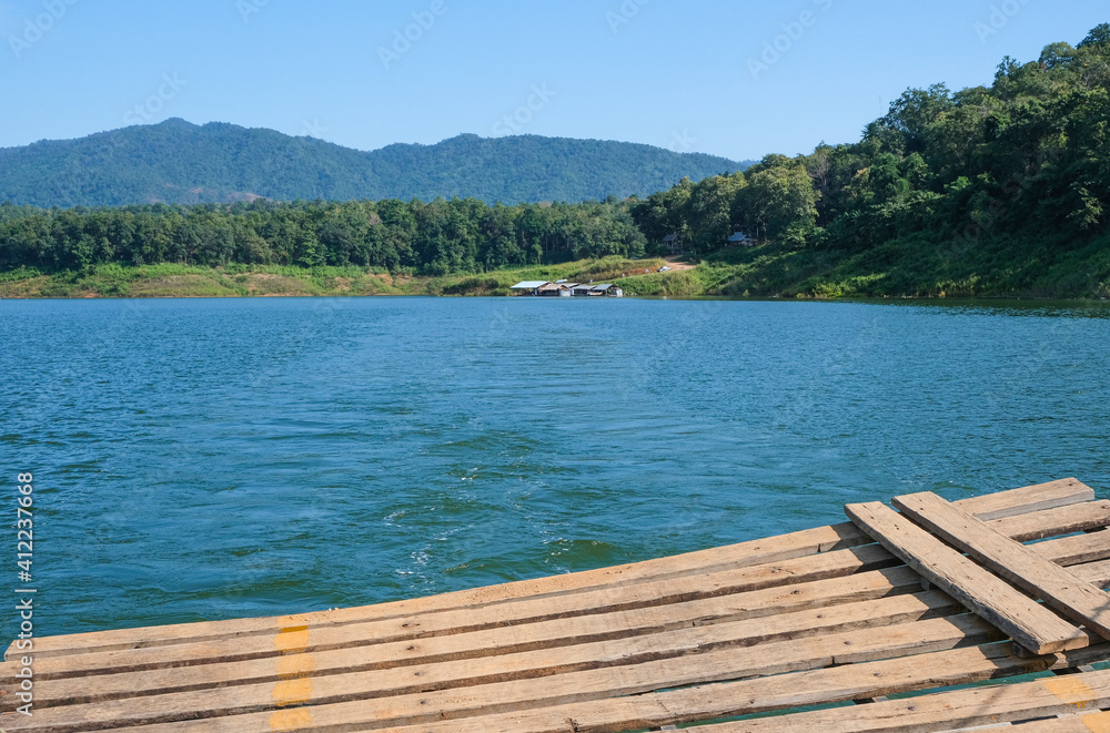 wooden plank on pier in thailand dam in morning day green  mountain natural view