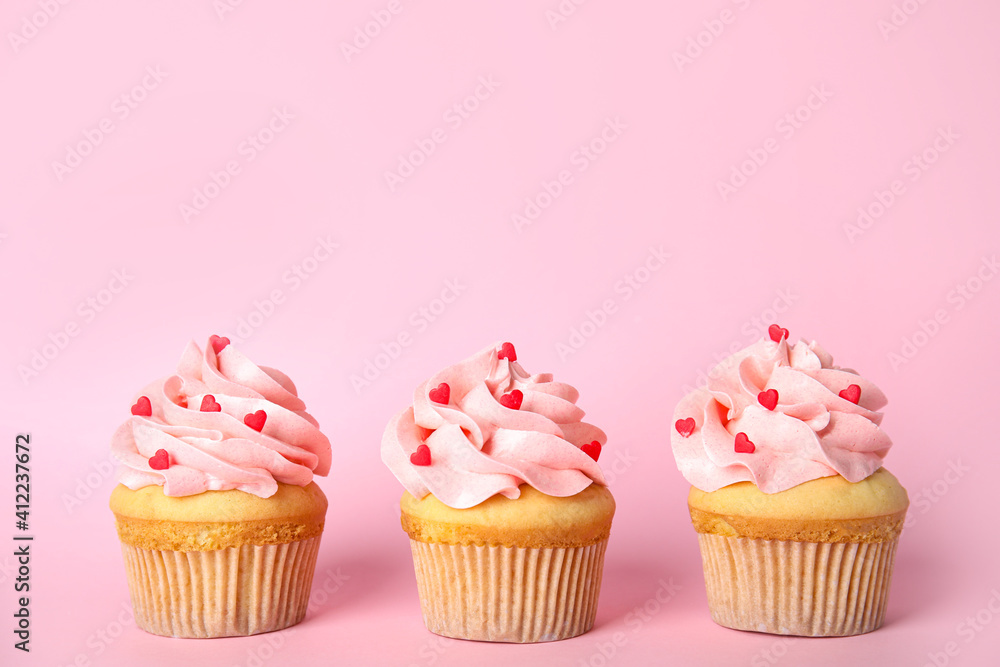 Row of tasty cupcakes on pink background, space for text. Valentine's Day celebration