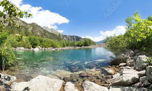Mountain lake with crystal clear water among the forest between the rocks