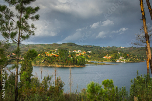 Landscape view of Castelo de Bode waterdam in Portugal. Houses on the riverside of Zezere river photo