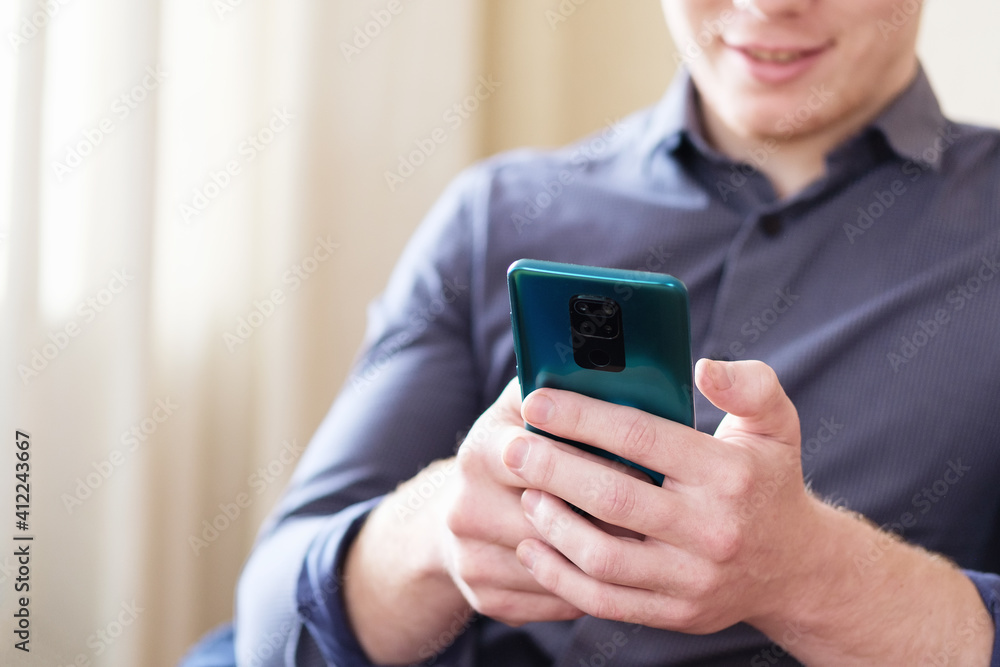 Millennial uses a mobile phone to view content on social networks - A businessman uses a smartphone to send a text message or sms - The concept of modern technology and remote work and communication Millennial uses a mobile phone to view content on social networks - A businessman uses a smartphone to send a text message or sms - The concept of modern technology and remote work and communication