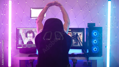 Streaming gamer stretch hands before gaming on futuristic neon lights setup
