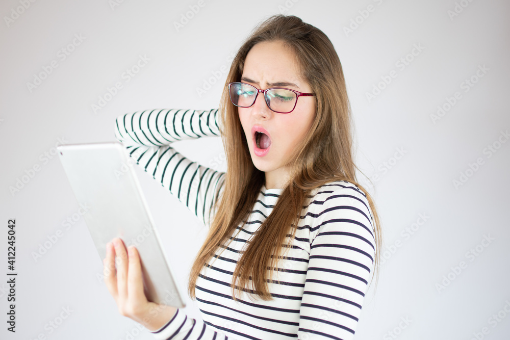 Surprised young girl using digital tablet over white background, copy space Surprised young girl using digital tablet over white background, copy space