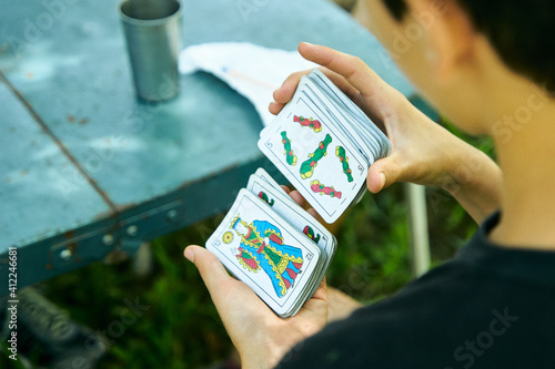 Personas Latinoamericanas jugando a las cartas de truco al aire libre. Familia jugando