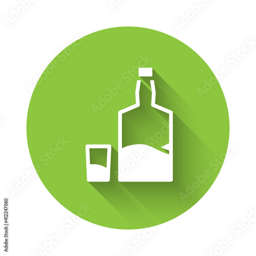 White Tequila bottle and shot glass icon isolated with long shadow. Mexican alcohol drink. Green circle button. Vector.