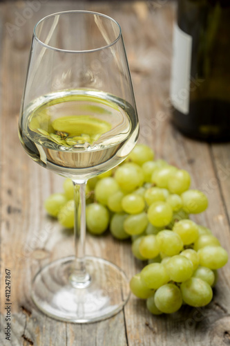 Weinglas mit Weintrauben auf Holzuntergrund