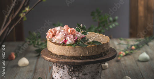 Delicious and beautiful raw cake decorated with tenderness fresh flowers. Concept of romantic mood and spring atmosphere