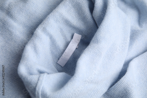 Warm light blue cashmere sweater with clothing label, closeup