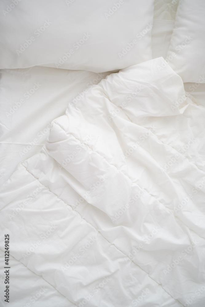 Obraz premium Soft white pillows on messy bed, closeup.