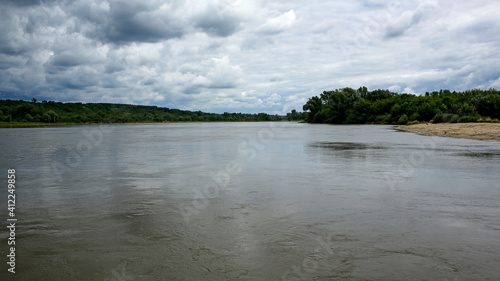 wide Vistula river with sandy shore and storm clouds in Kazimierz Dolny, Poland
