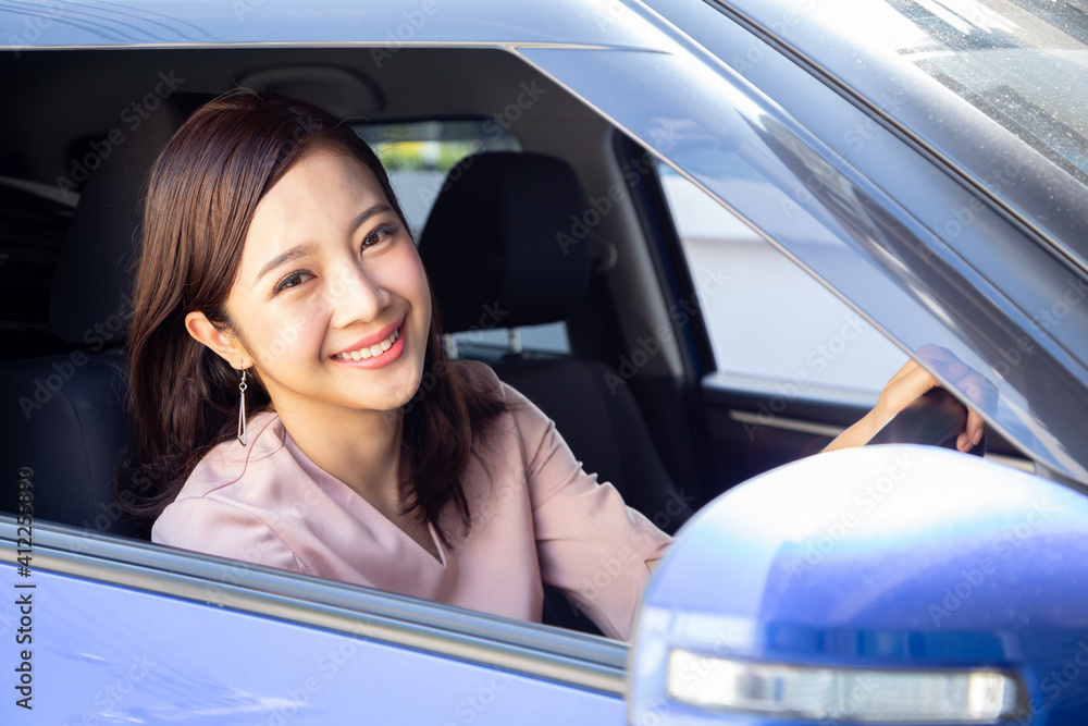 Driver Asian woman smiling and sitting inside car on the road