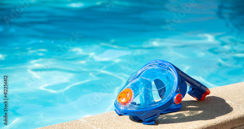 swimming mask with snorkel near the blue pool on a sunny tropical morning photo
