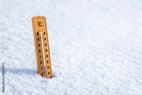 Thermometer in the snow background concept for winter and freezing temperature