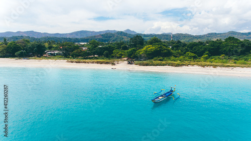 Aerial view of small wooden boat on calm beach. Beautiful landscape captured by drone.