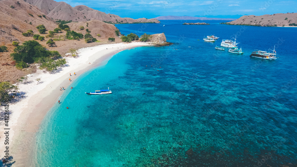 Aerial view of white sand beach in Pink Beach, Labuan Bajo, Indonesia. Sailing boat in Komodo National Park.