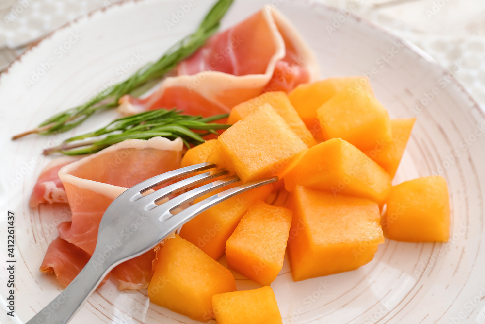 Plate with delicious melon, fork and prosciutto, closeup Plate with delicious melon, fork and prosciutto, closeup