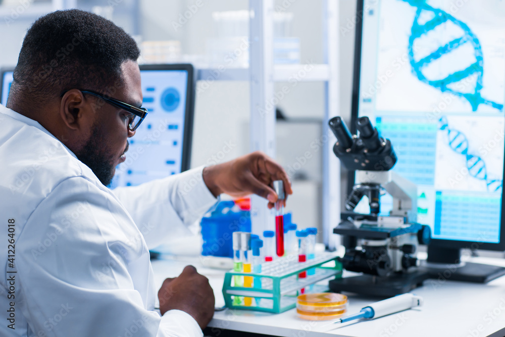 Professional African-American scientist is working on a vaccine in a modern scientific research laboratory. Genetic engineer workplace. Future technology and science. Professional African-American scientist is working on a vaccine in a modern scientific research laboratory. Genetic engineer workplace. Future technology and science.