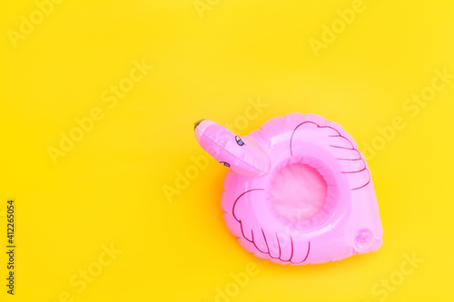 Fototapeta Naklejka Na Ścianę i Meble -  Summer beach composition. Simply minimal design with pink Inflatable flamingo isolated on yellow background. Pool float party, trendy celebrity fashion concept. Flat lay top view copy space.