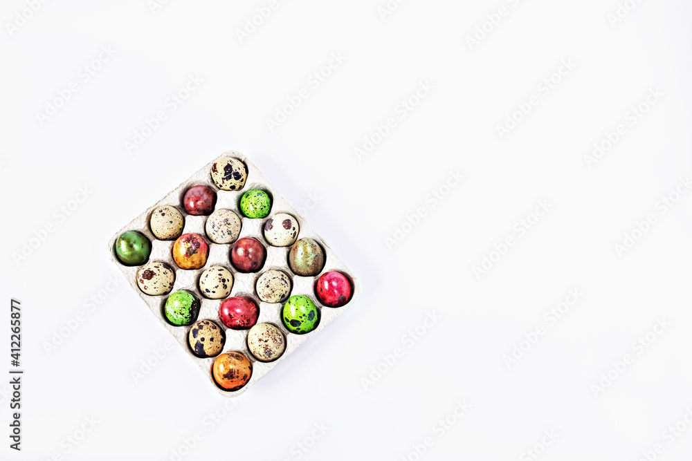 Colored quail Easter eggs in a box on the white background. Easter holiday concept Colored quail Easter eggs in a box on the white background. Easter holiday concept