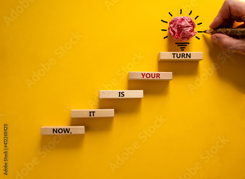 Business concept growth success process. Wood blocks stacking as step stair on yellow background, copy space. Businessman hand. Words 'now, it is your turn'. Conceptual image of motivation.