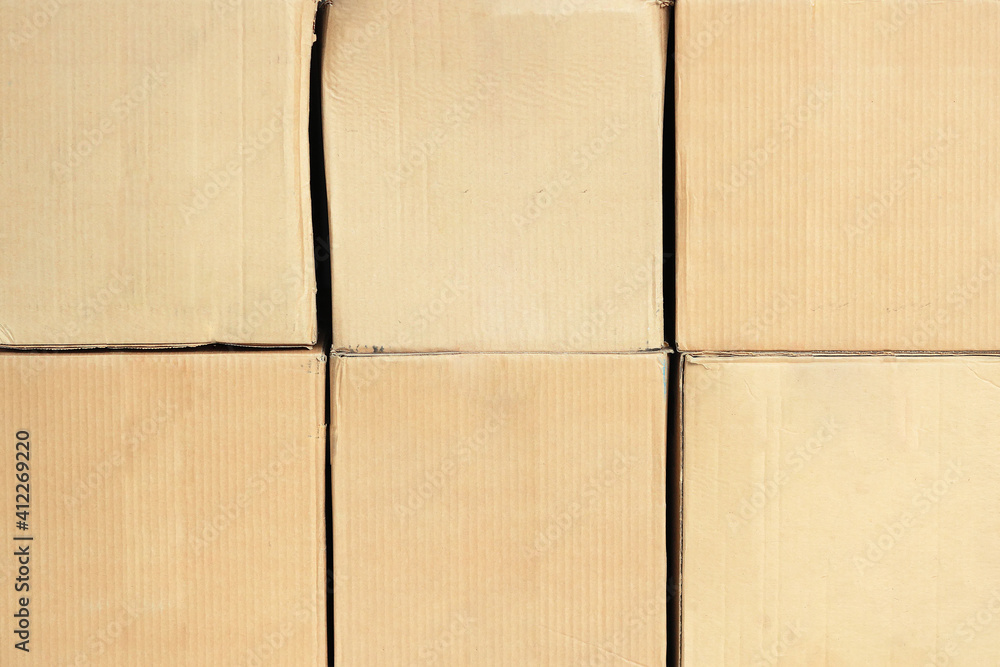 Fototapeta premium Square cardboard boxes in two rows in full screen. Front view with copy space. A blank for posting information about a logistics or transport company. Mockup