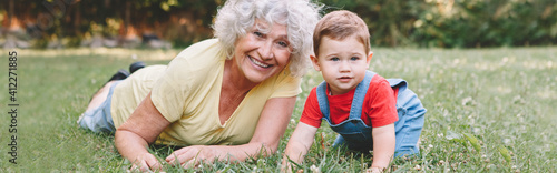 Billede på lærred Grandmother with grandson boy at home backyard