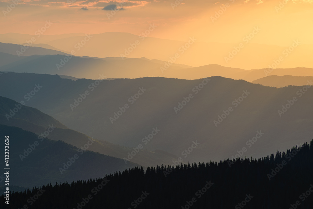Obraz premium Mountains during sunset. Lines of mountain slopes during sunset. Fog in the mountains. Sunlight. Natural landscape in the summertime.