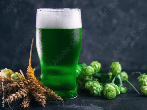 Close-up of a glass of green traditional Irish beer on St. Patrick's Day. green hops