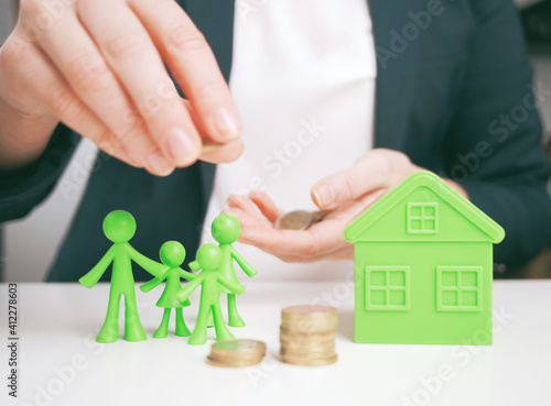 welfare benefits koncept. Hands of woman making a gesture of protection over family and home with piggy bank. House construction and savings insurance concept. Property insurance and security concept.