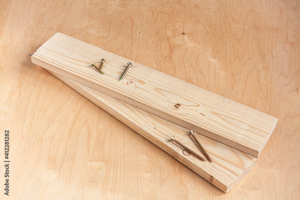 self-tapping screws and two wood boards on wooden background