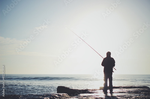 Fisherman on a pier with angry sea