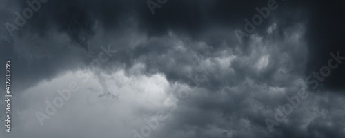 Background of dark stormy ominous clouds in gray moody sky