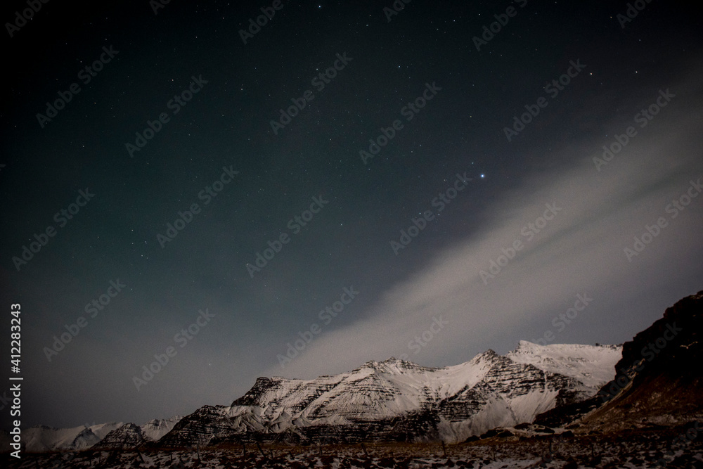 starry sky and Northern lights with snowy peaks