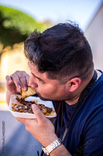 Mexicano comiendo tacos de guisos sentado en mexico © Mylifeontopdm
