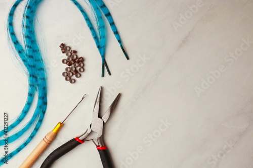Tools and fake feather hair on ;ight background