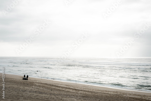 people admiring the vastness of the sea from a beach