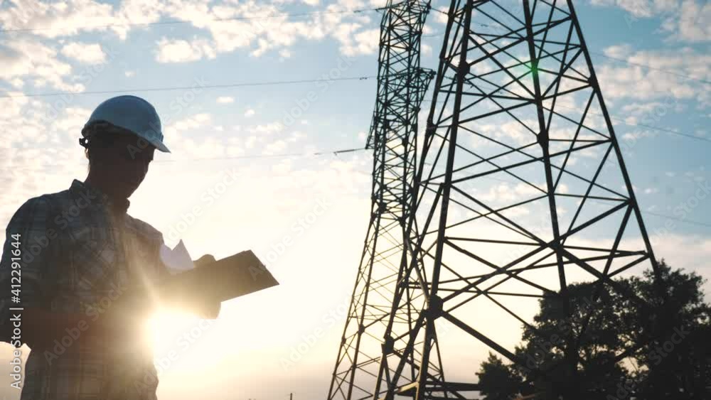 silhouette of an electrician engineer working next to an electrical support tower energy. electricity high voltage tower support. electrical engineer sunset inspect voltage electricity pylon silhouette of an electrician engineer working next to an electrical support tower energy. electricity high voltage tower support. electrical engineer sunset inspect voltage electricity pylon